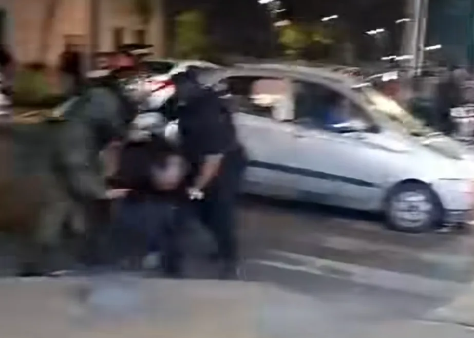 Funcionarios reducen a una persona en el suelo junto a un auto durante el operativo nocturno en la Pequeña Caracas